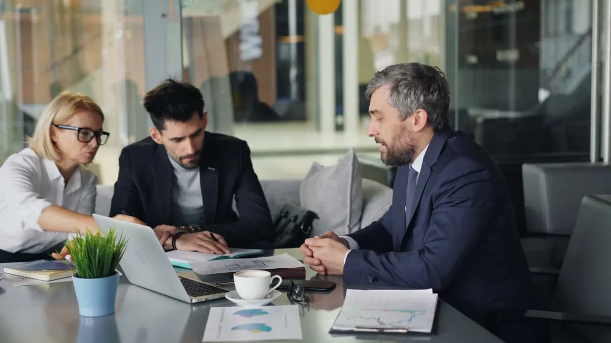 Two consultants reviewing charts and reports at a desk